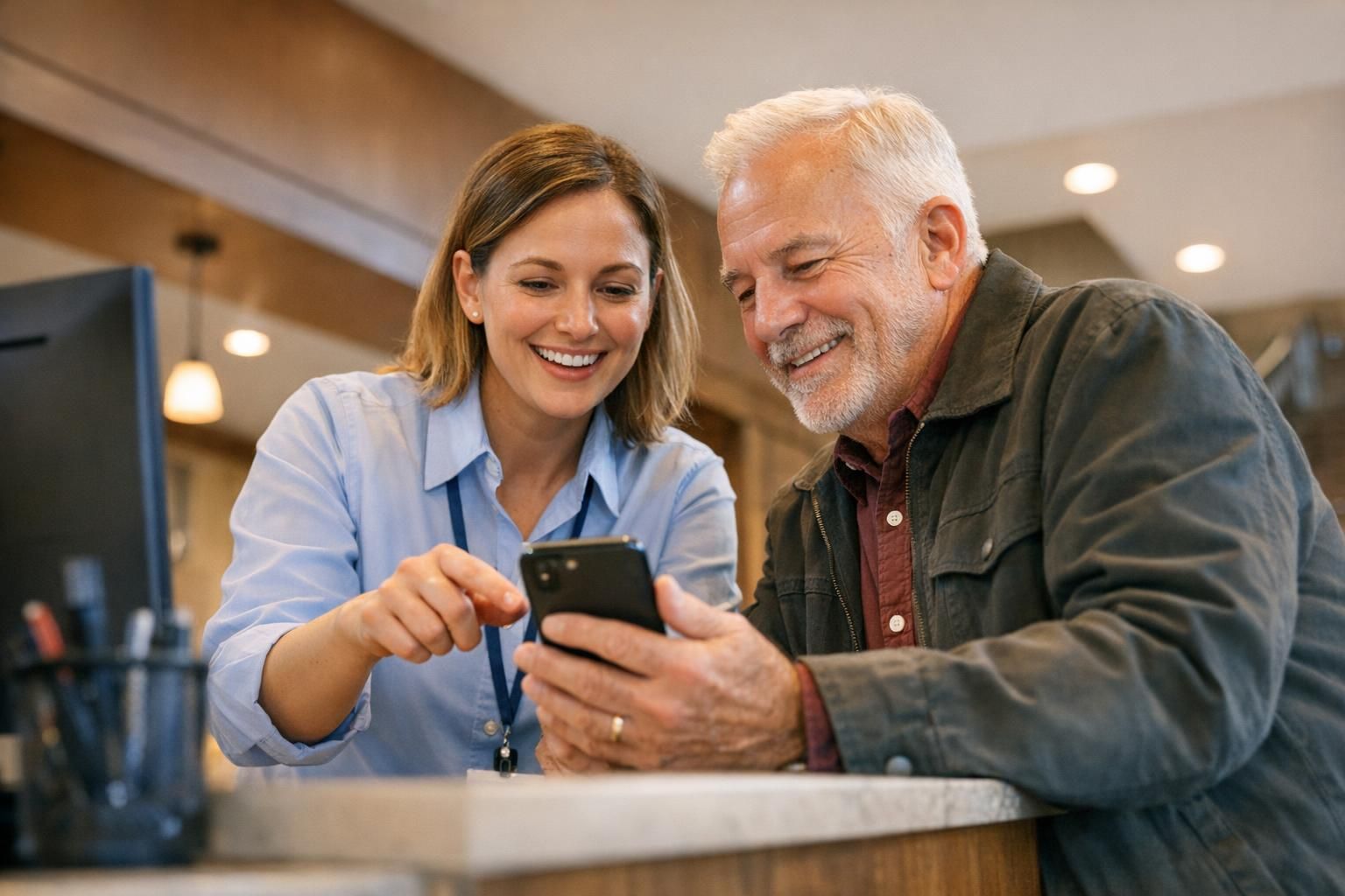 Agent municipal aidant un administré connecté au WiFi public à l'accueil d'une mairie